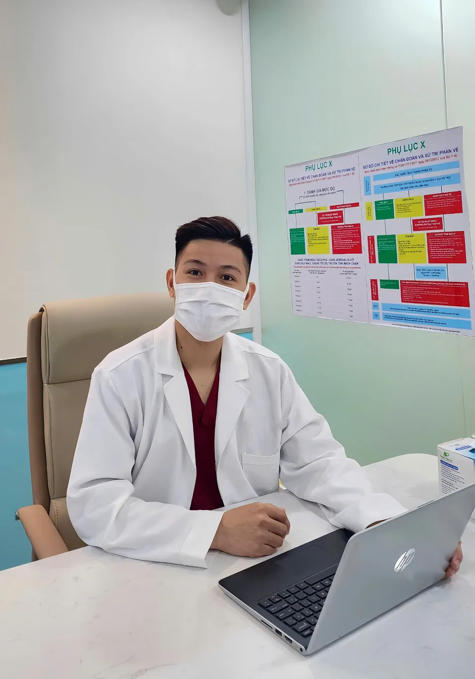 BS Thế Chuyển đeo khẩu trang làm việc bên máy tính